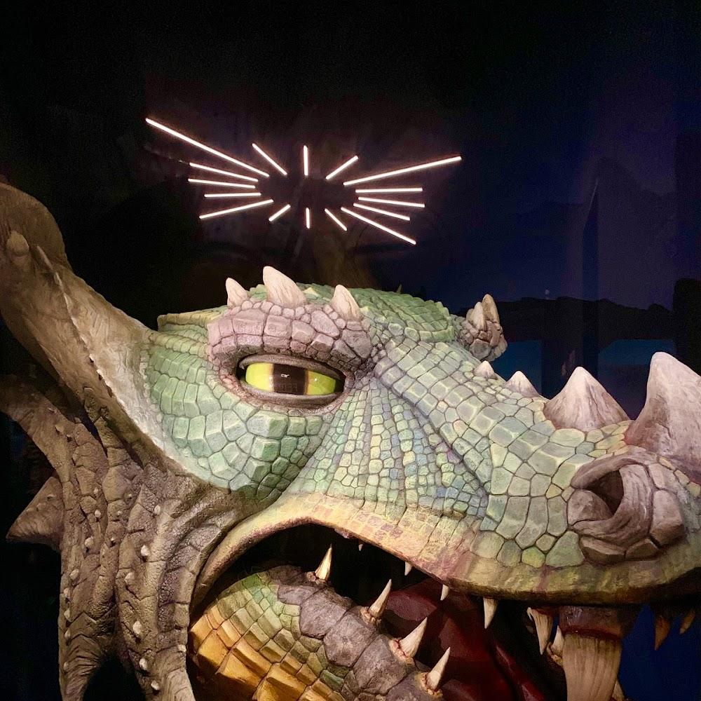 A large, green dragon sculpture with an open mouth.